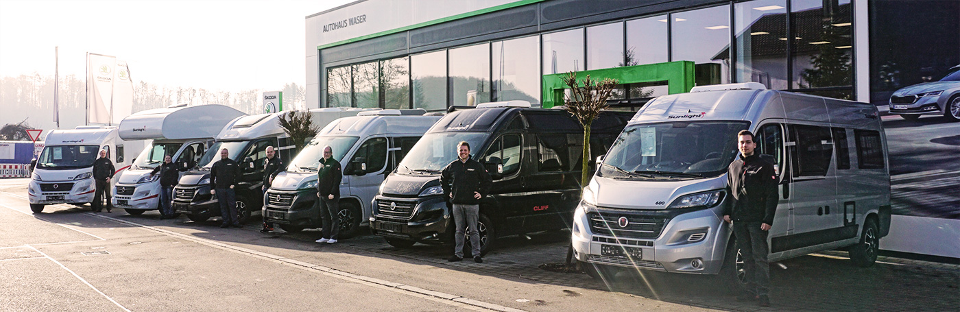 Wohnmobile und Team vor Autohaus